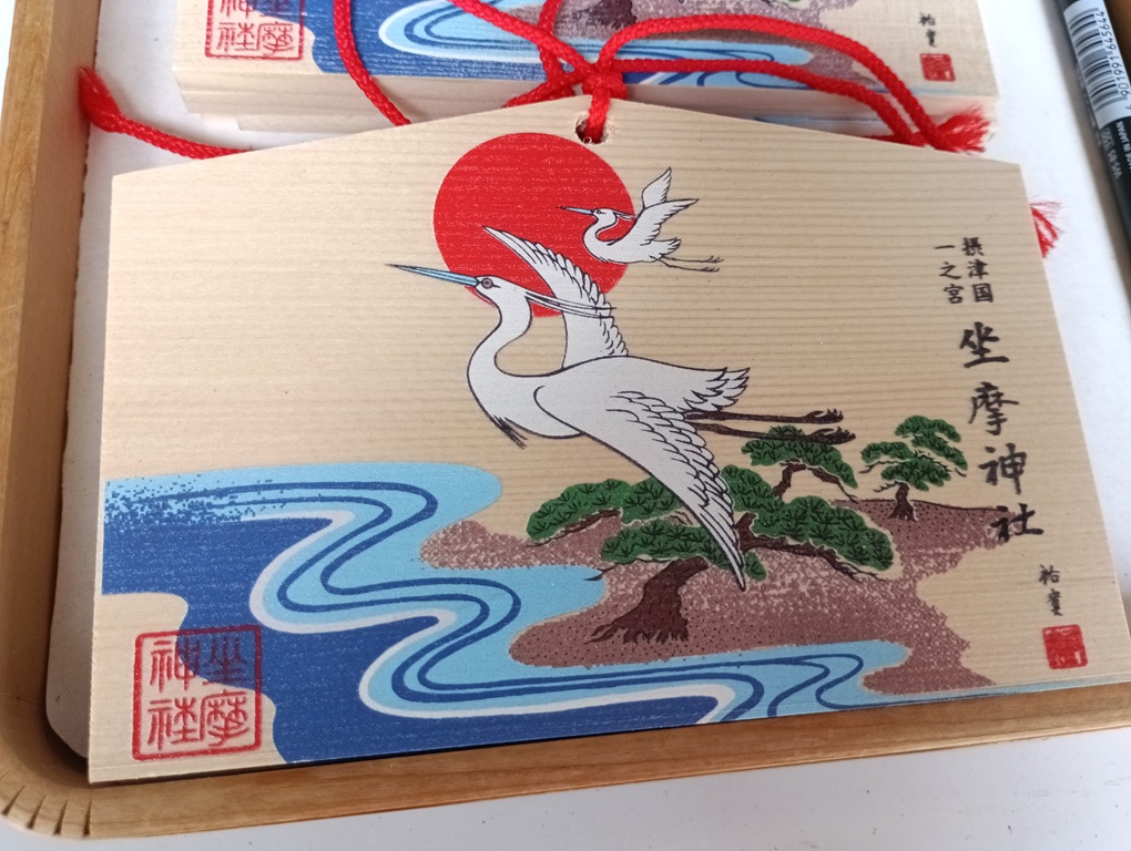 坐摩神社の絵馬。2羽の白鷺が飛び立つデザインで、希望とご縁を表す。